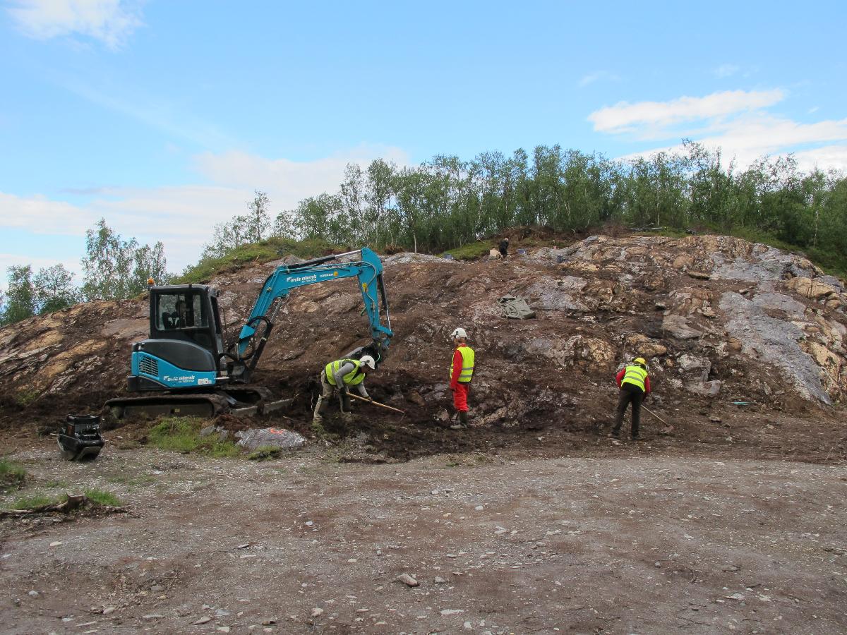 3 personer og en gravemaskin som graver i bakken